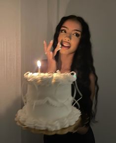 a woman holding a cake with candles in her mouth