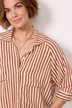 A drawstring hem adds a unique flair to this classic button-down by LNA. Crafted in lightweight fabric, this striped top features a collared neckline, relaxed fit, and two chest pockets. Pair with your favorite cutoffs and sandals for a polished summer look. Casual Shirt With Vertical Stripes And Shirttail Hem, Button-up Shirt With Striped Collar For Day Out, Day Out Button-up Shirt With Striped Collar, Day Out Shirt With Striped Collar Button-up, Casual Tops With Vertical Stripes And Shirttail Hem, Chic Striped Blouse With Shirttail Hem, Fall Button-up Shirt With Vertical Stripes, Casual Striped Blouse For Daywear, Spring Tops With Vertical Stripes And Shirttail Hem