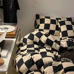 a black and white checkered comforter on a bed in a room with other items