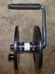 a close up of a barbell on the ground with two wheels attached to it