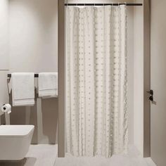 a white shower curtain in a bathroom next to a toilet