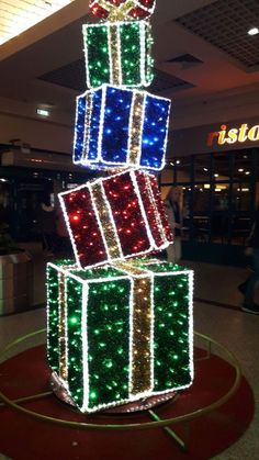 christmas presents are stacked on top of each other in the middle of an airport lobby