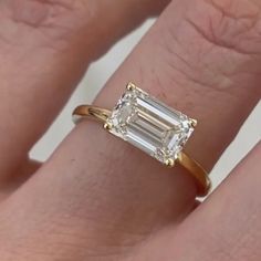 a woman's engagement ring with an emerald cut diamond