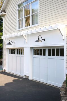 a white garage with two lights on each side and an attached door to the other side