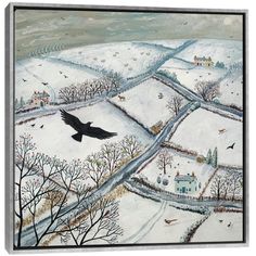 a black bird flying over a snow covered field with houses and trees in the background