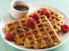 waffles with syrup and raspberries on a plate