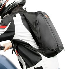 a man riding on the back of a motorcycle wearing a black and white jacket with red stripes