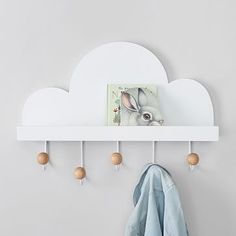 a white shelf with coat hooks and a bunny on it