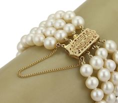 "This gorgeous retro bracelet has four strands of cream tone lustrous 7mm pearls. The rectangular box shape clasp is lovely with filigree floral design and chain attached for added security. Close to the clasp is a long bar on each side securing the strands together. Material: 14k yellow gold Measurement: inner circumference: 6.5\" band is 1.06\" wide x 0.26\" high Weight: 46.2 grams" Elegant Cream Bracelet For Formal Occasions, Elegant Cream Bracelet For Formal, Cream Bracelet For Formal Occasions, Cream Colored Bracelet For Formal Occasions, Cream Formal Bracelet Jewelry, Cream Colored Formal Bracelet Jewelry, Elegant Cream Round Bracelet, Elegant Multi-strand Bracelet For Formal Events, Gold Pearl Bracelet