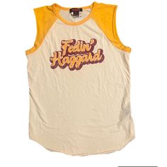 Feeling Haggard Graphic Tee From Cavender’s. Vintage Tank T-shirt For Summer, Retro Tank Tops With Letter Print, Sleeveless Graphic Tee For Spring, Spring Sleeveless Graphic Tee, Sleeveless Spring Graphic Tee, Retro Crew Neck Tank Top For Summer, Retro Cotton Tank Top, Retro Yellow Tank Top For Spring, Retro Cotton Tank Top For Summer