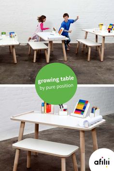 two children are sitting at small tables with books on them and one child is holding a pencil