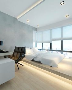 a bedroom with a bed, desk and chair next to a large window overlooking the city