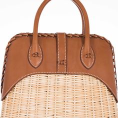 This Hermes Picnic Bolide, crafted in 2017, is an exquisite blend of rustic charm and refined elegance. This unique bag marries the natural beauty of Osier Wicker with the luxurious touch of Fauve Barenia leather, creating an accessory that is both visually stunning and tactilely inviting. The body of the bag is made from finely woven Osier Wicker, evoking the essence of serene summer days and elegant countryside escapades. This natural material adds an element of artisanal craftsmanship and giv Elegant Leather Straw Bag With Detachable Handle, Elegant Brown Straw Bag With Woven Leather, Elegant Leather Woven Straw Bag, Elegant Rectangular Leather Straw Bag, Elegant Leather Straw Bag With Leather Handles, Elegant Brown Handwoven Straw Bag, Elegant Handwoven Brown Straw Bag, Luxury Straw Bag With Woven Leather Basket, Luxury Leather Straw Bag With Bamboo Handle