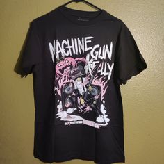 T-Shirt Machine Gun Kelly Edgy Black T-shirt For Fan Merchandise, Black Alternative Style Top For Fans, Alternative Black T-shirt With Front Print, Black Crew Neck T-shirt For Concert, Alternative Black Tops With Logo Print, Alternative Style Black Tops With Logo Print, Black Urban Tops For Fan Merch, Black Urban Top For Fan Merchandise, Pre-shrunk Short Sleeve Punk Shirt