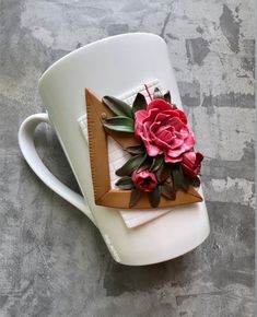 a coffee cup decorated with flowers and leaves