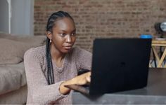 a woman sitting in front of a laptop computer