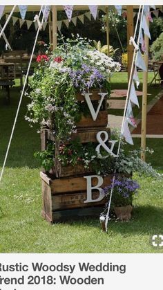 a wooden box with flowers and bunting in it sitting on the grass under a tent