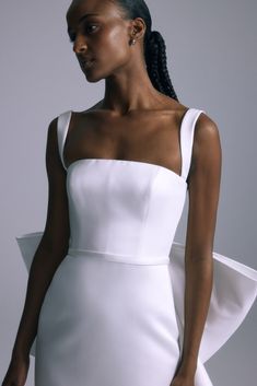 a woman wearing a white dress with one shoulder and an asymmetrical top