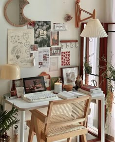 a desk with a computer, lamp and pictures on the wall