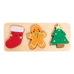 three wooden christmas decorations on a white background with one ginger, one snowman and one tree