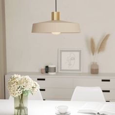 a vase with flowers sitting on top of a white table