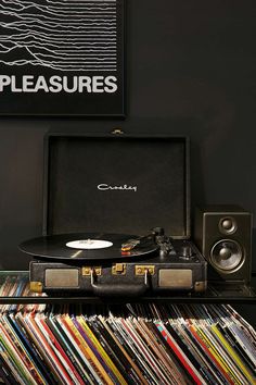 an old record player sitting on top of a table next to a vinyl album case