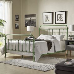 a green metal bed frame in a bedroom with white walls and carpeted flooring