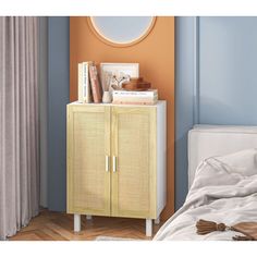 a white and yellow cabinet with books on top next to a bed in a room