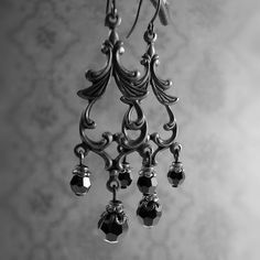 Romantic jet black Swarovski crystals dangling from Victorian style chandelier filigree. The filigree and ear wires are raw brass that I hand-oxidize to the Gothic inspired black finish.---------------------------------------------------------------------------------------------Dimensions and details:- Largest beads measure 6mm in diameter- From the top of the ear wires to the bottom of the earrings, they measure approximately 2 1/8 inches (5 4mm)- Filigree is USA-made raw brass, which I have ag Elegant Black Jewelry With Antique Finish, Silver Brass Chandelier Earrings With Intricate Design, Victorian Brass Dangle Chandelier Earrings, Victorian Dangle Chandelier Earrings In Brass, Gothic Silver Brass Earrings, Silver Brass Chandelier Earrings For Party, Black Ornate Dangle Jewelry, Ornate Black Dangle Jewelry, Black Filigree Dangle Jewelry