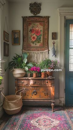 an old dresser with potted plants on it in front of a blue door and window