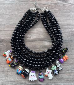 A fun and unique beaded charm statement necklace made with black acrylic beads and Halloween themed charms. - Shortest strand measures 18.75- 20.75”- Charms measure approx. 1" long- Beads are 10mm- Lead free pewter connector - Stainless steel lobster claw (or sterling silver) - 2" Stainless steel extender chain The mannequin's neck size is 14.5". We use the highest quality findings to ensure a piece that will last for years to come. DLD jewelry comes with a lifetime guarantee. This necklace is handmade in the USA. Dana LeBlanc Designs- Handmade Jewelry Black Halloween Necklace With Lobster Clasp, Black Themed Necklace For Halloween, Halloween Themed Black Necklace, Themed Black Necklace For Halloween, Halloween Beaded Black Jewelry, Black Beaded Jewelry For Halloween, Halloween Black Jewelry With Charms, Black Halloween Jewelry With Charms, Black Novelty Jewelry With Charms