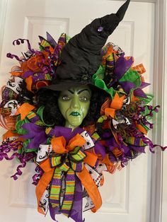 a halloween wreath with a witch's head and green eyes on the front door