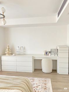 a bedroom with white furniture and accessories on the floor