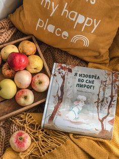 apples and other fruit on a bed with a pillow that says, my happy place