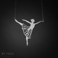 a ballerina necklace is shown on a black background with the silhouette of a dancer