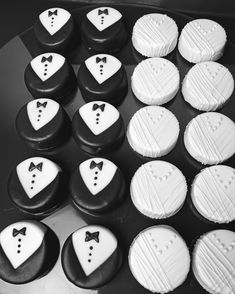 black and white cupcakes with bow ties and tuxedo cookies on them