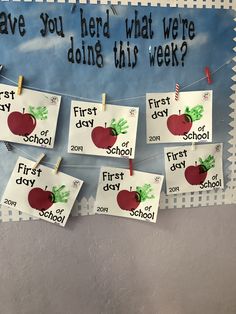 bulletin board with first day of school pictures and handprints on clothes pegs