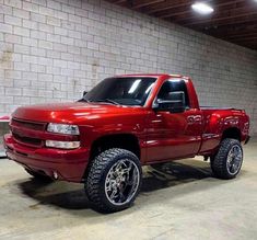 a red pick up truck parked in a garage