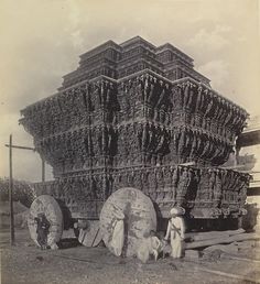 an old black and white photo of people standing in front of a large structure made out of logs