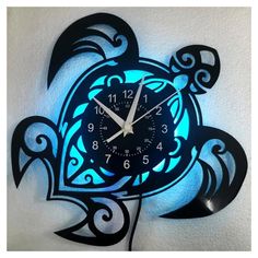 a clock that is on the wall with blue light coming from it's face