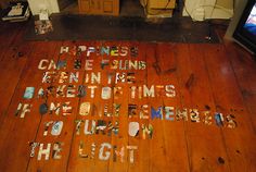 a wooden floor with words written in different languages on it and a television screen behind it