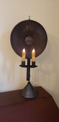 three candles are lit in front of a large metal object