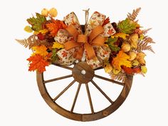 a wooden wheel with autumn leaves and bows on it