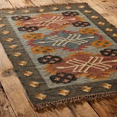 an old rug is on the floor with wooden floors and wood planks in the background