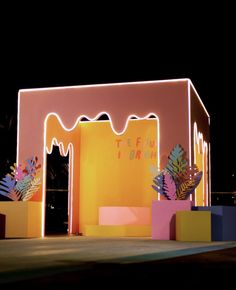 an outdoor stage set up for a birthday party at night with decorations and lights on it