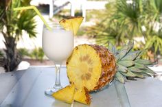 a pineapple next to a glass of milk on a table