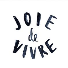 the words joie de vivre are drawn in black ink on a white background