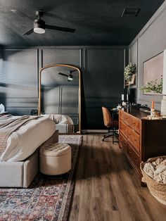 a bedroom with black walls and wooden floors