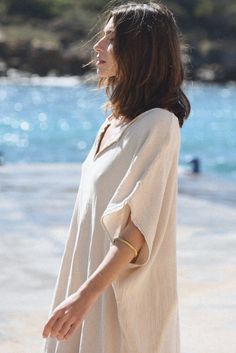 Style // Whether you call it beige, cream or off-white, our Moon is the perfect oatmeal color kaftan When comfort meets style, the Cala Kaftan features a billowy, shapeless silhouette and mid-length. With a v-neck silhouette, wide sleeves and two side slits, it promises to be your go-to look for that cozy, effortless look. The lightweight linen-cotton blend fabric is extra soft, to ensure you won't ever want to take it off Fabric Note // Made in Italy from a Linen & Cotton blend Sizing Advice // Oversized V-neck Tunic For Beach Cover-up, Summer Beige Flowy Kaftan, Beige Flowy Kaftan For Summer, Flowy Beige Kaftan For Summer, Summer V-neck Tunic For Loungewear, Spring Linen V-neck Kaftan, White Oversized V-neck Kaftan, Linen V-neck Tunic For Summer, Casual Beige Kaftan For Spring