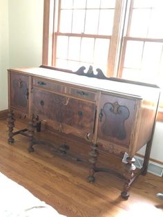 an old dresser is sitting on the floor in front of a window with sunlight streaming through it